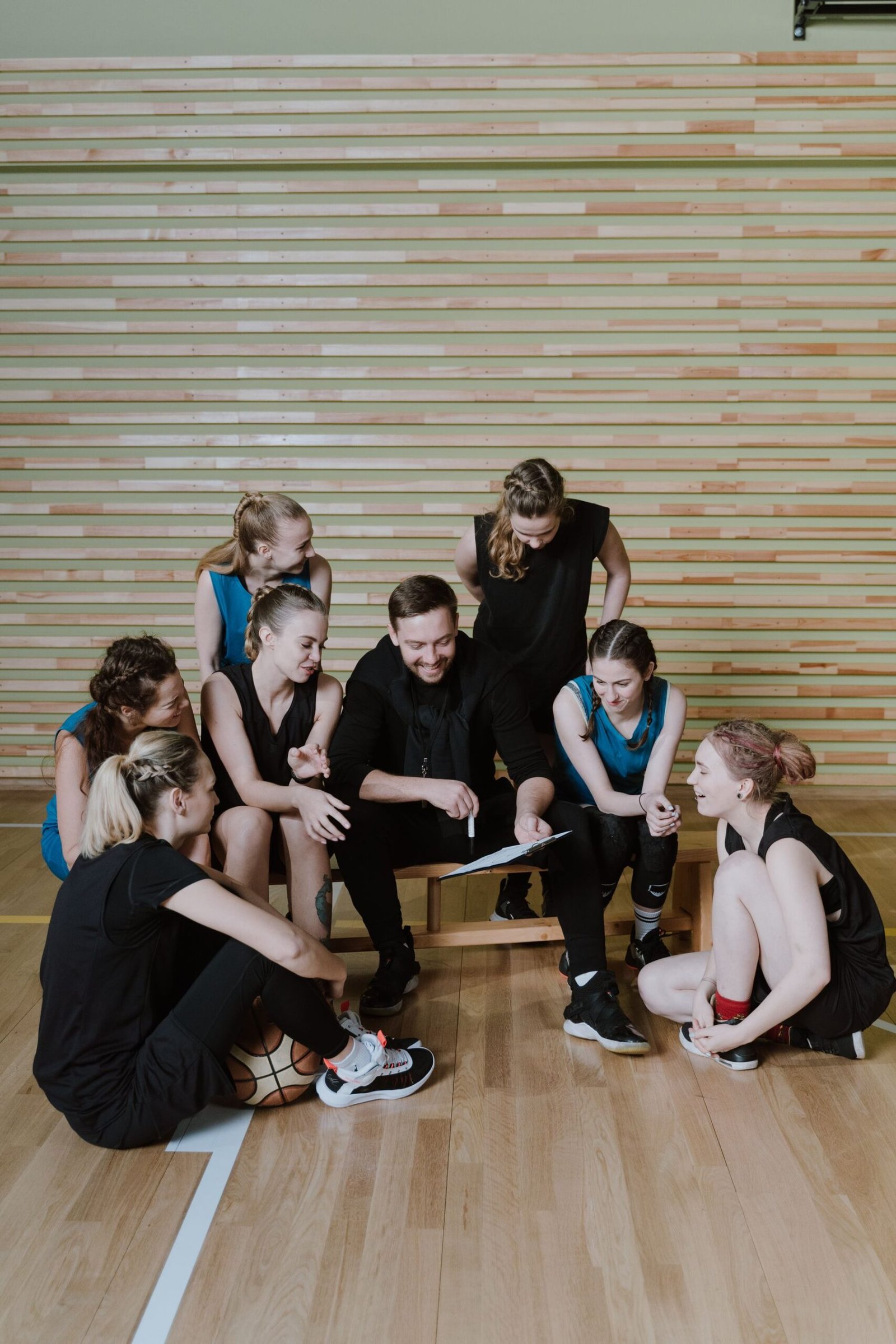 A coach going through a plan with the team in a gym